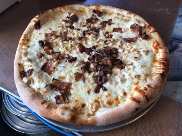 Chicken Ranch Supreme Pizza with ranch sauce, chicken, bacon and fresh garlic